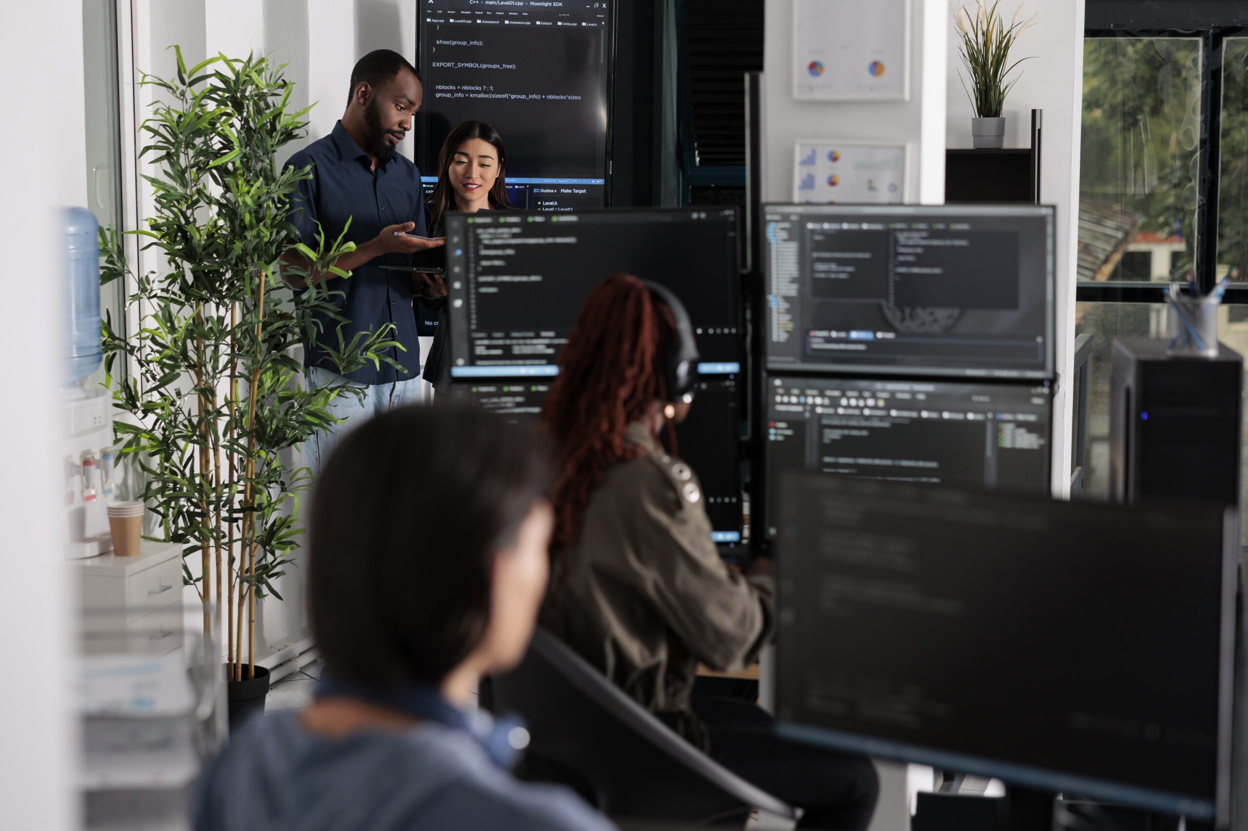 Software programmers discussing about algorithms on big screen and laptop, analyzing html code language. Team of system engineers looking at database on terminal window, server interface.